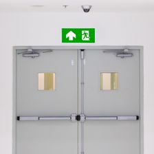 close-up-the-green-fire-exit-sign-with-the-door-exit (1)